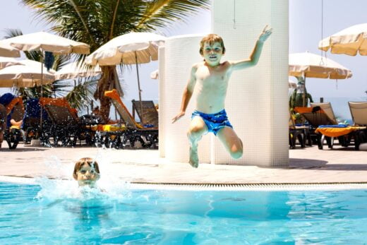 Deux joyeux petits enfants garçons sauter dans la piscine