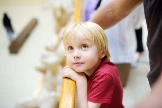 Petit garçon regardant l’exposition dans un musee