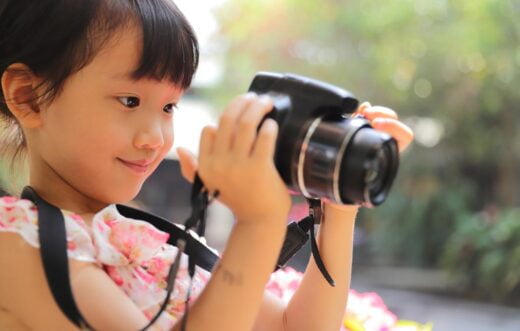 Une jeune fille prend des photos avec un appareil photo numérique