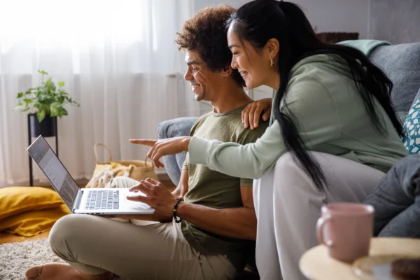 Un couple heureux regarde les produits qu'il s'apprête à acheter en ligne