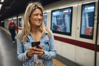 Une jeune touriste utilise un téléphone en attendant le tramway