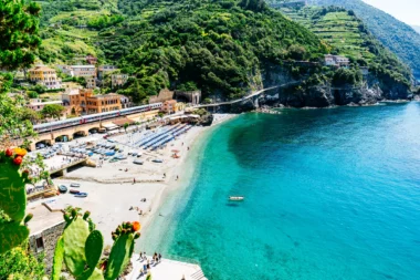 Village avec des maisons colorées et des bateaux sur une plage de sable à Cinque Terre, Italie.