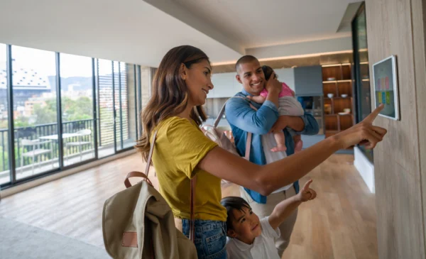 Une famille  quittant la maison en verrouillant la porte à l’aide d’un système de sécurité automatisé.