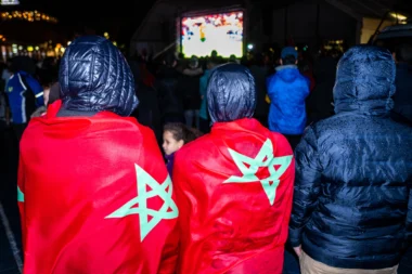 Les fans de l’équipe nationale marocaine de football regardent sous la pluie le match de l'équipe nationale sur la place Jemaa el Fna à Marrakech, au Maroc.